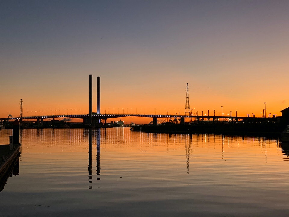 Photo across the bay with the sunsetting behind the Bolte Bridge 