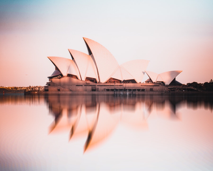 Sunrising over the Sydney Opera House with its reflection in the water